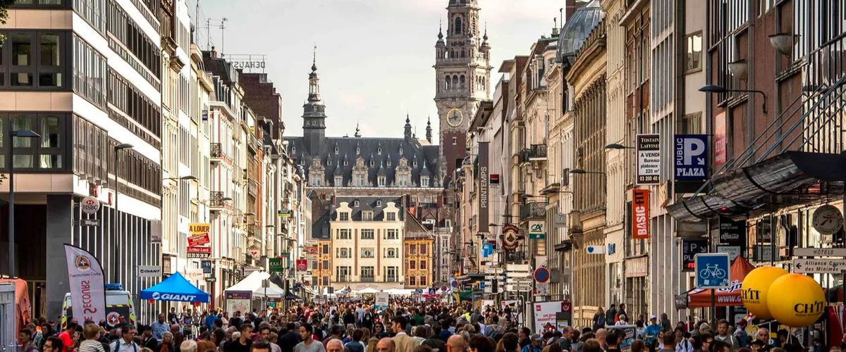 Foule de chineurs dans les rues du centre de Lille pendant la Braderie — VTC disponible pour vos allers-retours